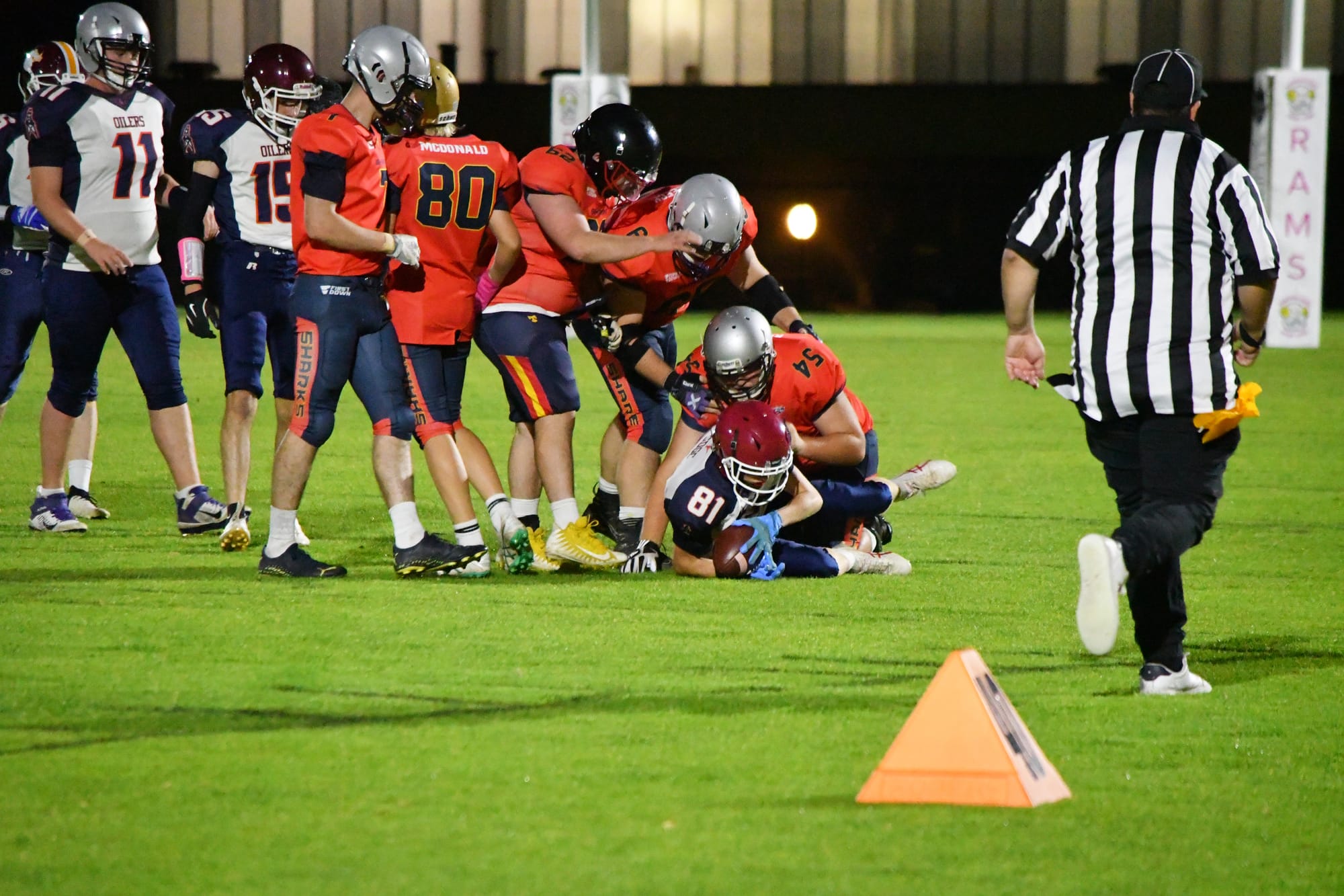 Sharks players tackle an Oilers player.