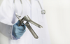 Male Doctor Instinctively Gives Tongs A Few Test Clicks Like He’s About To Fire Up The Weber
