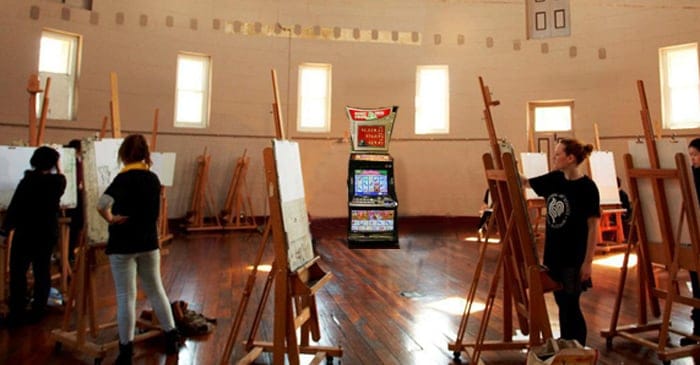 Students vow to keep painting even if they are surrounded by the zapping lights and noises of pokie machines