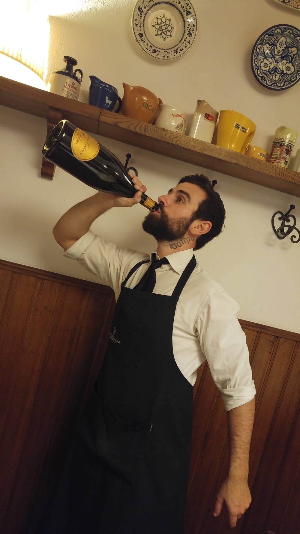 Francesco, The Italian Sommelier, beve ironicamente da una bottiglia gigante di vino al ristorante, per sdrammatizzare il mondo del vino.