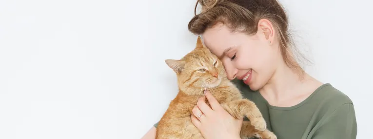 Una mujer acariciando a su gato.