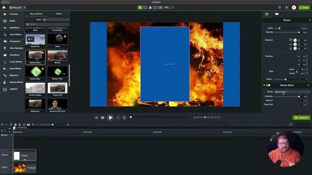 Camtasia canvas showing Alpha Invert mode with a blue background visible through a rectangular cutout in the firefighter image