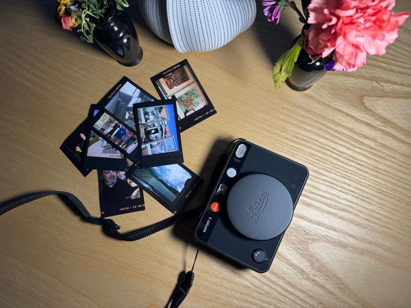 Leica Sofort 2 Camera and Photos on a table 