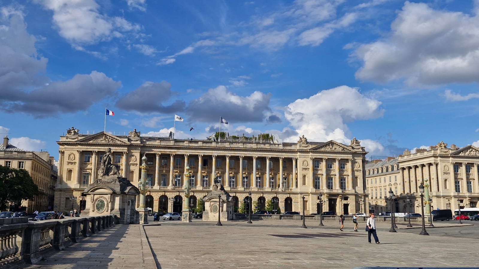 A wide exterior view of the FIA headquarters building located at Place de la Concorde in Paris under a bright sky with scattered clouds.