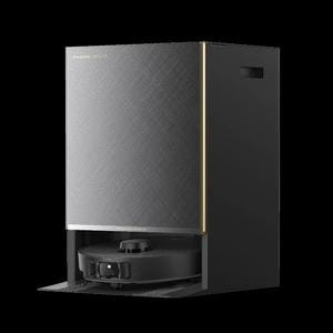 A studio shot of a Dreame robot vacuum cleaner docked inside its dark textured base station with subtle gold accents against a plain white background.