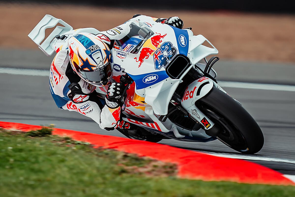 Jack Miller riding a KTM MotoGP motorcycle leaning heavily into a turn on a racetrack.