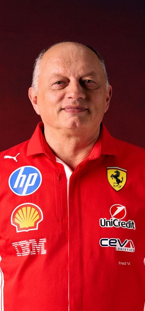 Portrait of Fred Vasseur wearing a red Scuderia Ferrari polo shirt with various sponsor logos.