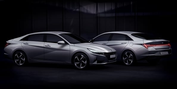 Two silver Hyundai Elantra Hybrid sedans shown in a dark studio setting, with one angled towards the front left and the other towards the rear right.