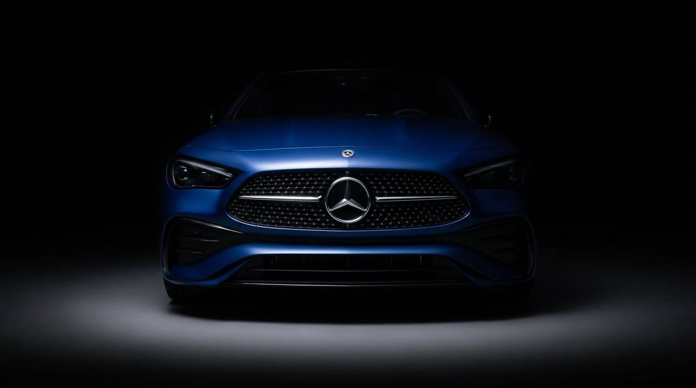 Blå Mercedes-AMG CLE Mythos tagen rakt framifrån i mörk studiobelysning.