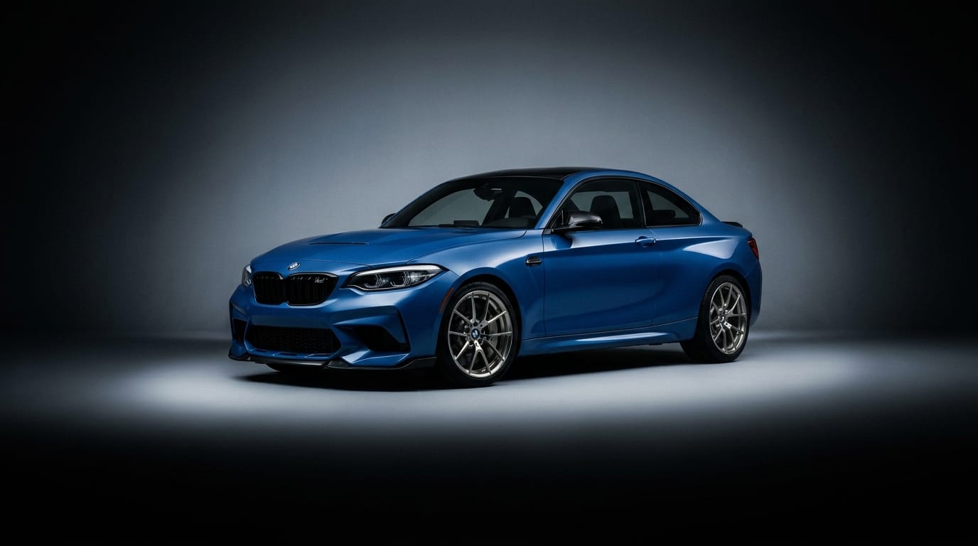 Blå BMW M2 CS uppställd i en mörk fotostudio med riktat ljus på karossen.