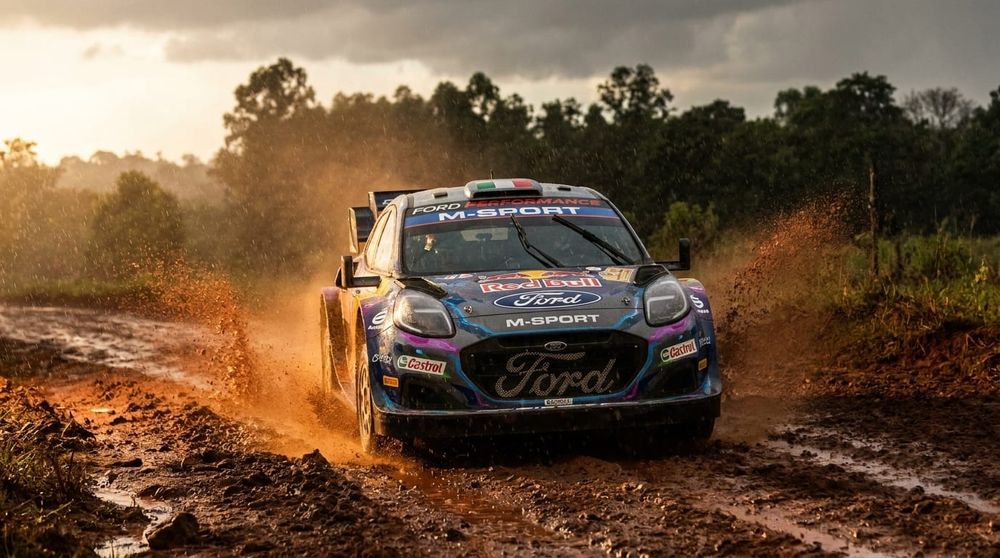 M-Sport Ford WRC rallybil navigerar på en lerig och vattendränkt grusväg med stänkande lera i Paraguay.