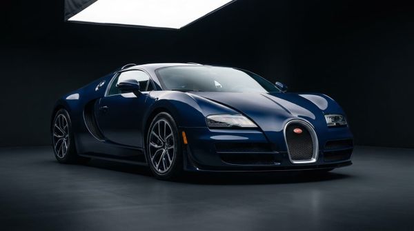 En mörkblå Bugatti Veyron i en studiomiljö sedd från en låg trekvartsvinkel framifrån.