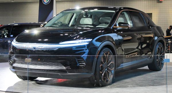 A front three-quarters shot of a black Chrysler Airflow concept vehicle displayed indoors at an auto show.