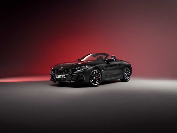 Studio photograph of a black BMW Z4 convertible in a front three-quarter view against a gradient background.