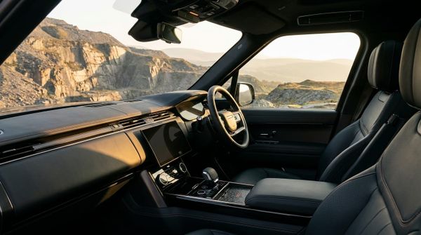 Interiör av 2027 Land Rover Range Rover Twenty Edition med läderklädsel och instrumentpanel, med utsikt över Dinorwig Quarry i Gwynedd, Wales.
