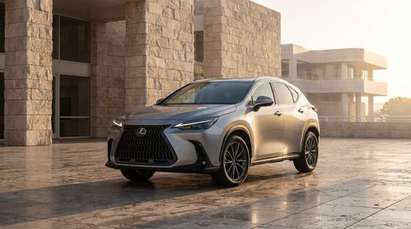 Silverfärgad Lexus NX parkerad på en stor öppen plats med monumental stenarkitektur i bakgrunden under gyllene timmen.