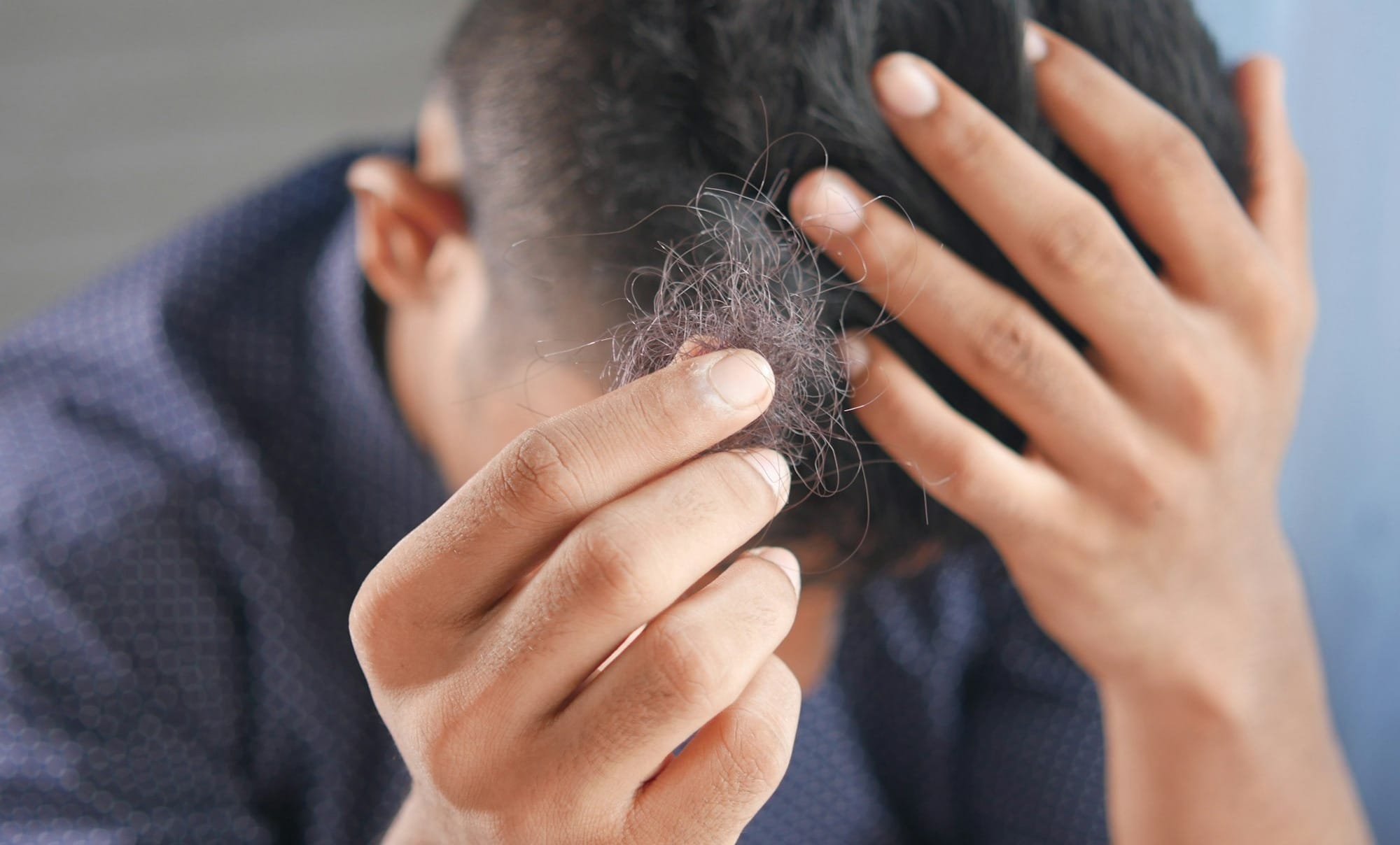 a man is combing his hair with his hands