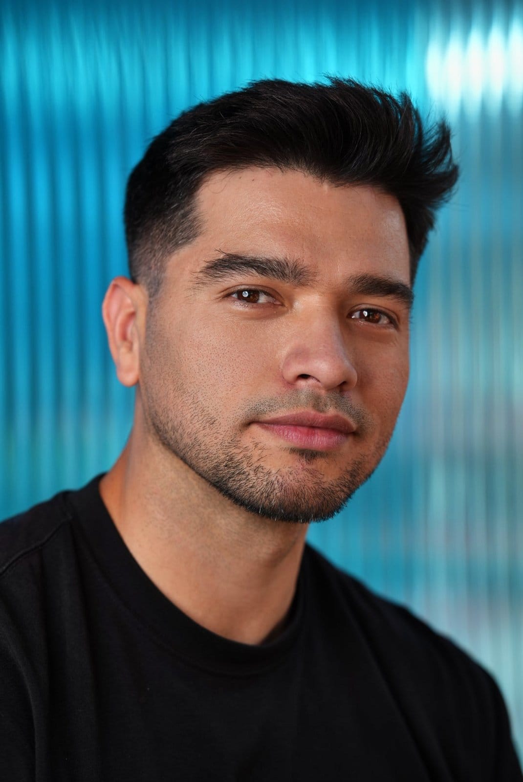 Portrait of Jorge Jaramillo in a black T-shirt against a blue background