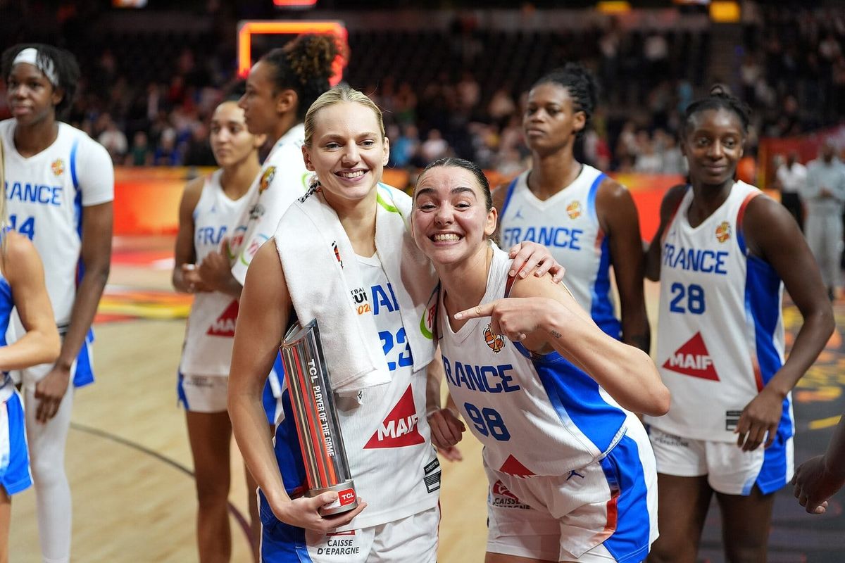 Marine Johannès holds her Player of the Game trophy as a smiling France teammate points to her