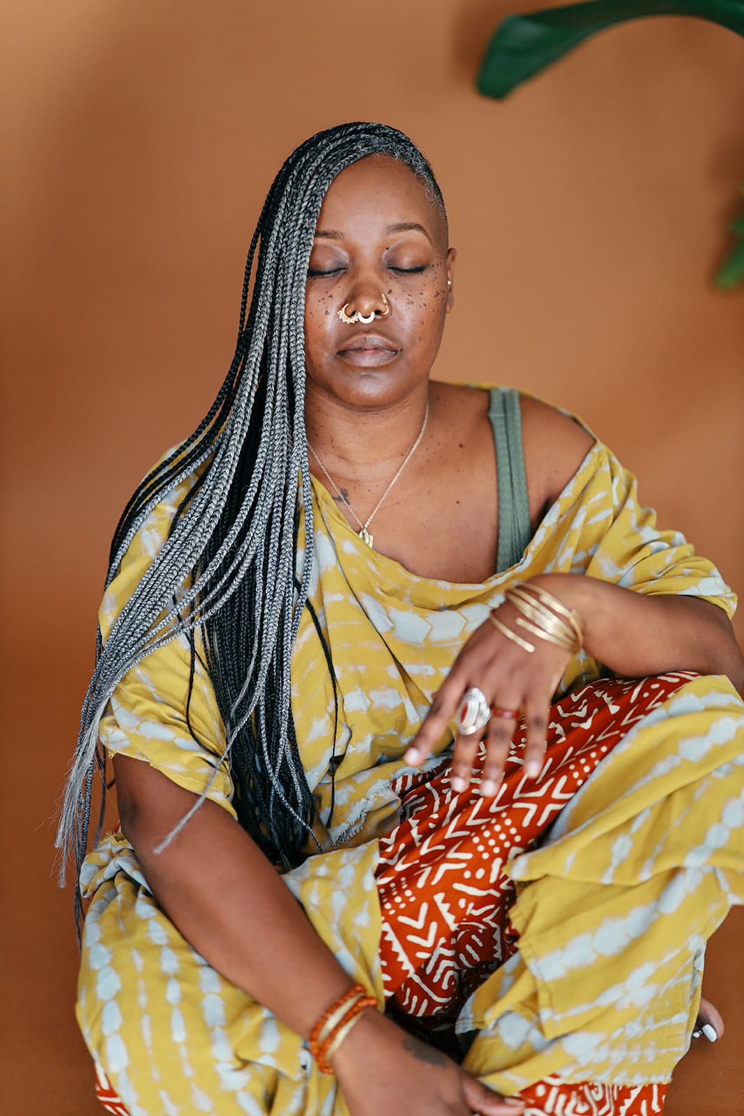 Yolonda Coles Jones seated comfortably on the floor with her eyes closed, meditating.