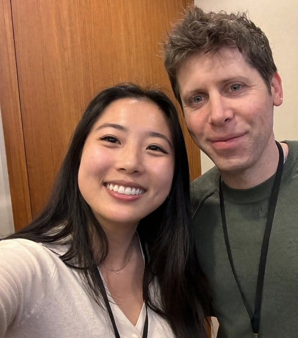young woman taking selfie with Sam Altman.