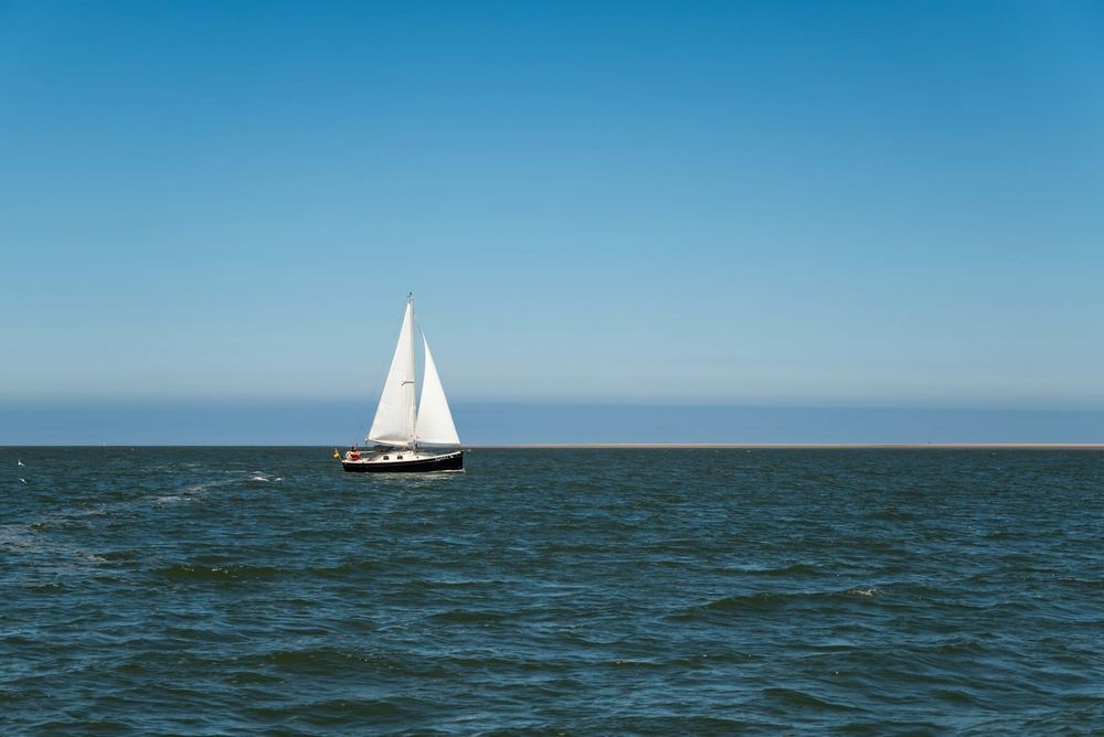 Sailboat under grey skies on a long offshore reach in moody North Atlantic light