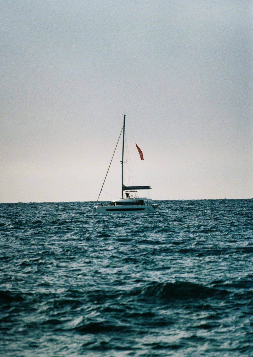 Anchored sailing yacht with mast and flag