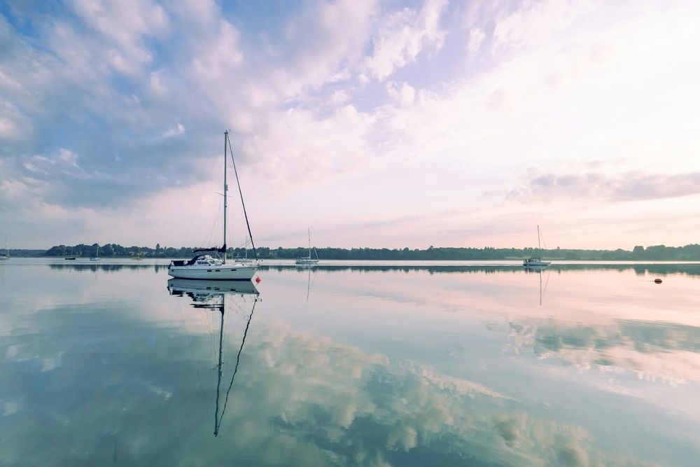 Sailboat at anchor in calm water at dawn
