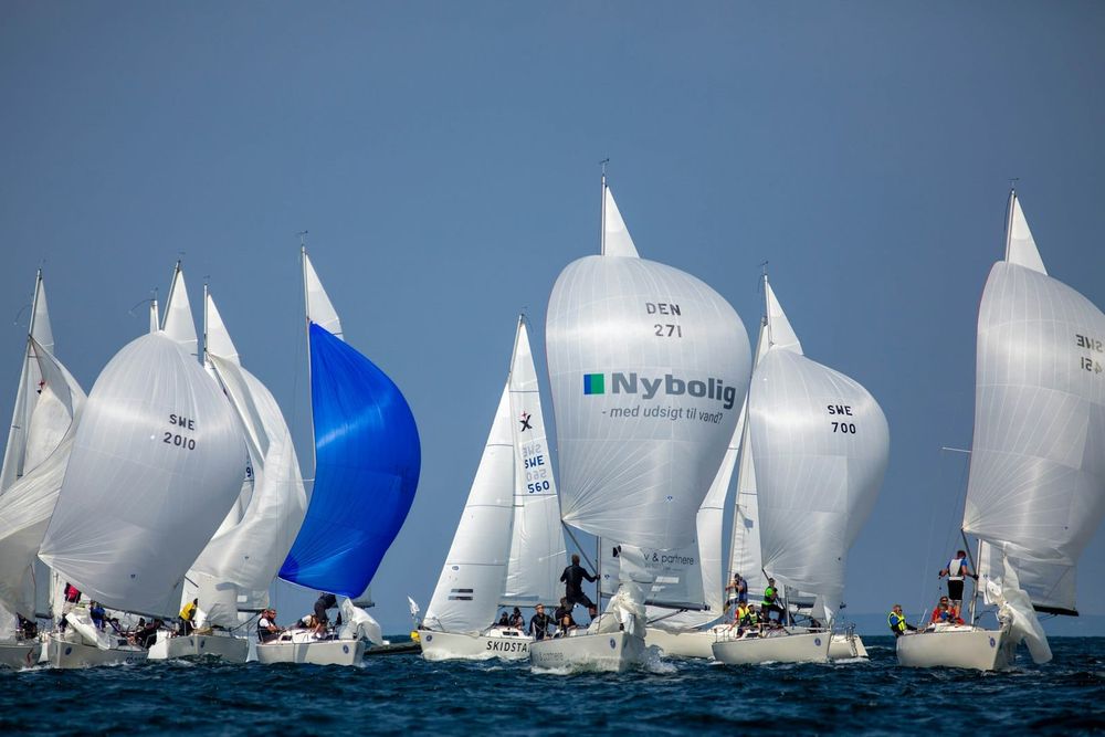 Fleet of racing yachts flying spinnakers downwind in close formation