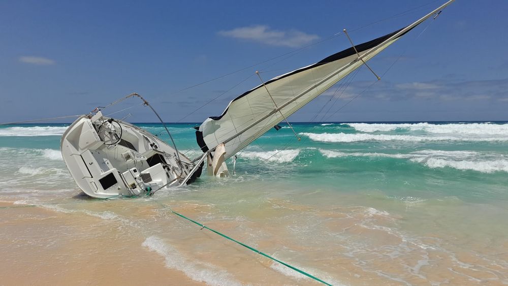 Heavy weather offshore — sailing yacht in rough seas under a gray sky