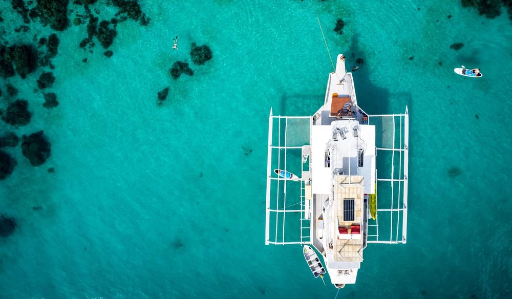White catamaran anchored in clear turquoise water