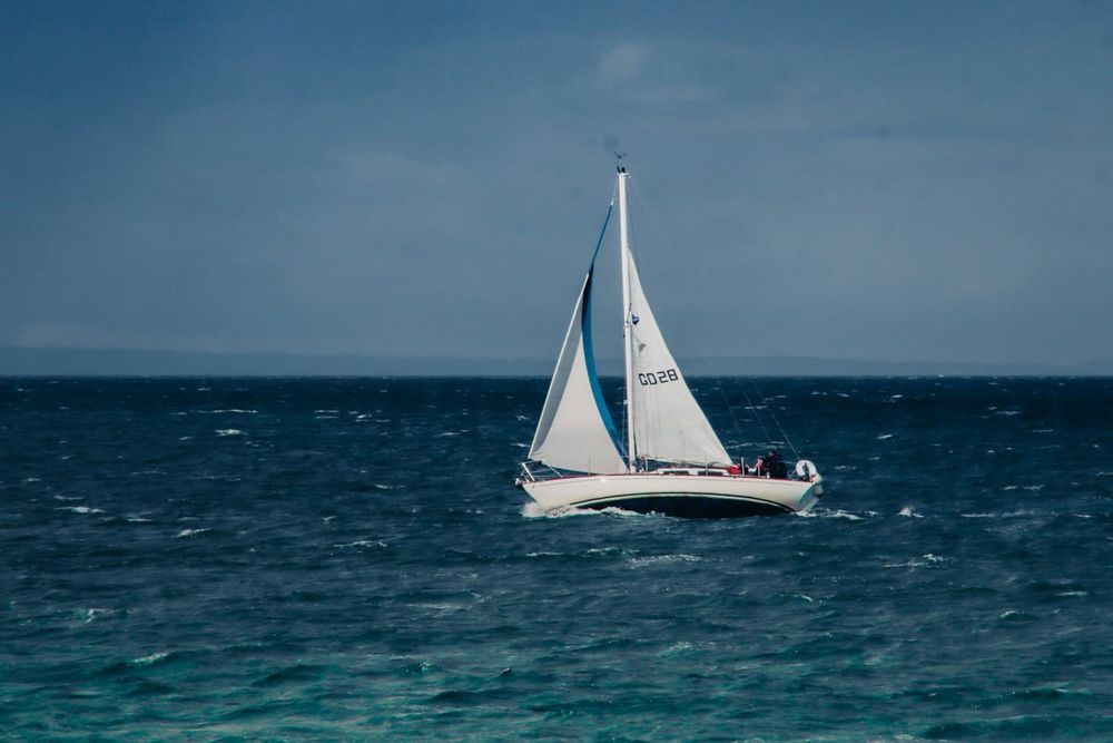 A catamaran under sail on open ocean water