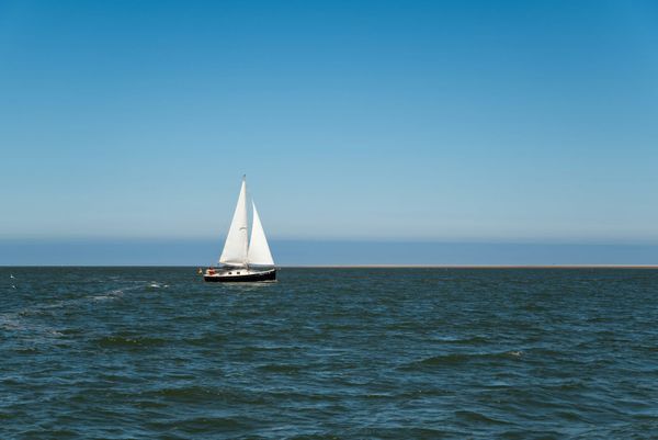 Sailboat under grey skies on a long offshore reach in moody North Atlantic light