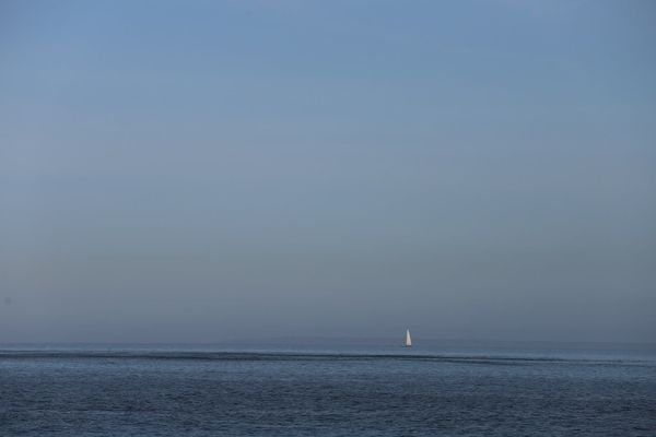 Sailing yacht under engine on a calm offshore morning