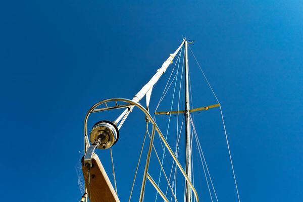 Mast and standing rigging viewed from below against a blue sky, with shrouds and spreaders in detail