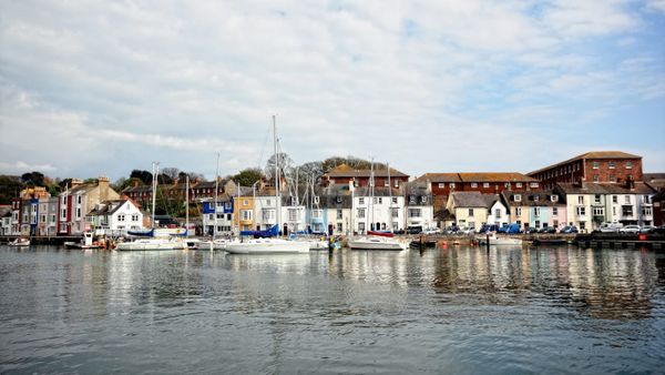 Harbor view with cruising sailboats and yachts moored in front of a town waterfront