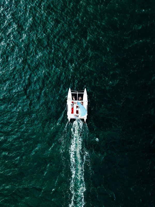 Aerial view of sailing catamaran on dark water