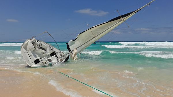 Heavy weather offshore — sailing yacht in rough seas under a gray sky