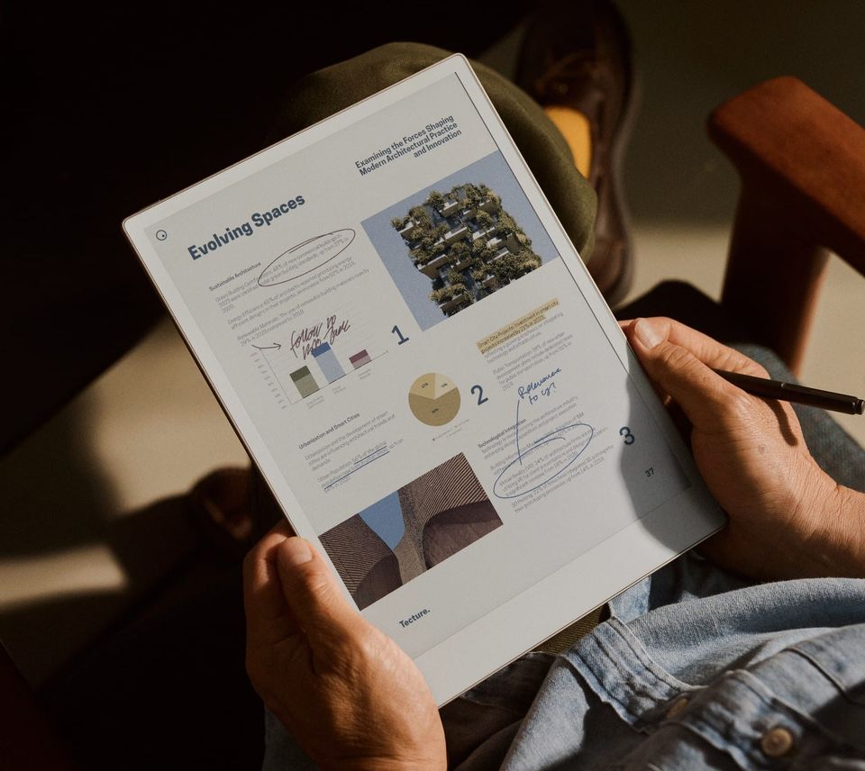 A person using a Marker to annotate an architecture document on a reMarkable Paper Pro tablet.
