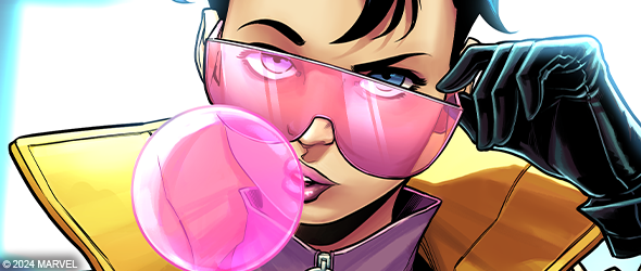 Jubilee blowing a bubble from some gum in her signature yellow jacket. She is tilting her glasses down in a sassy about to blow you up kind of way.