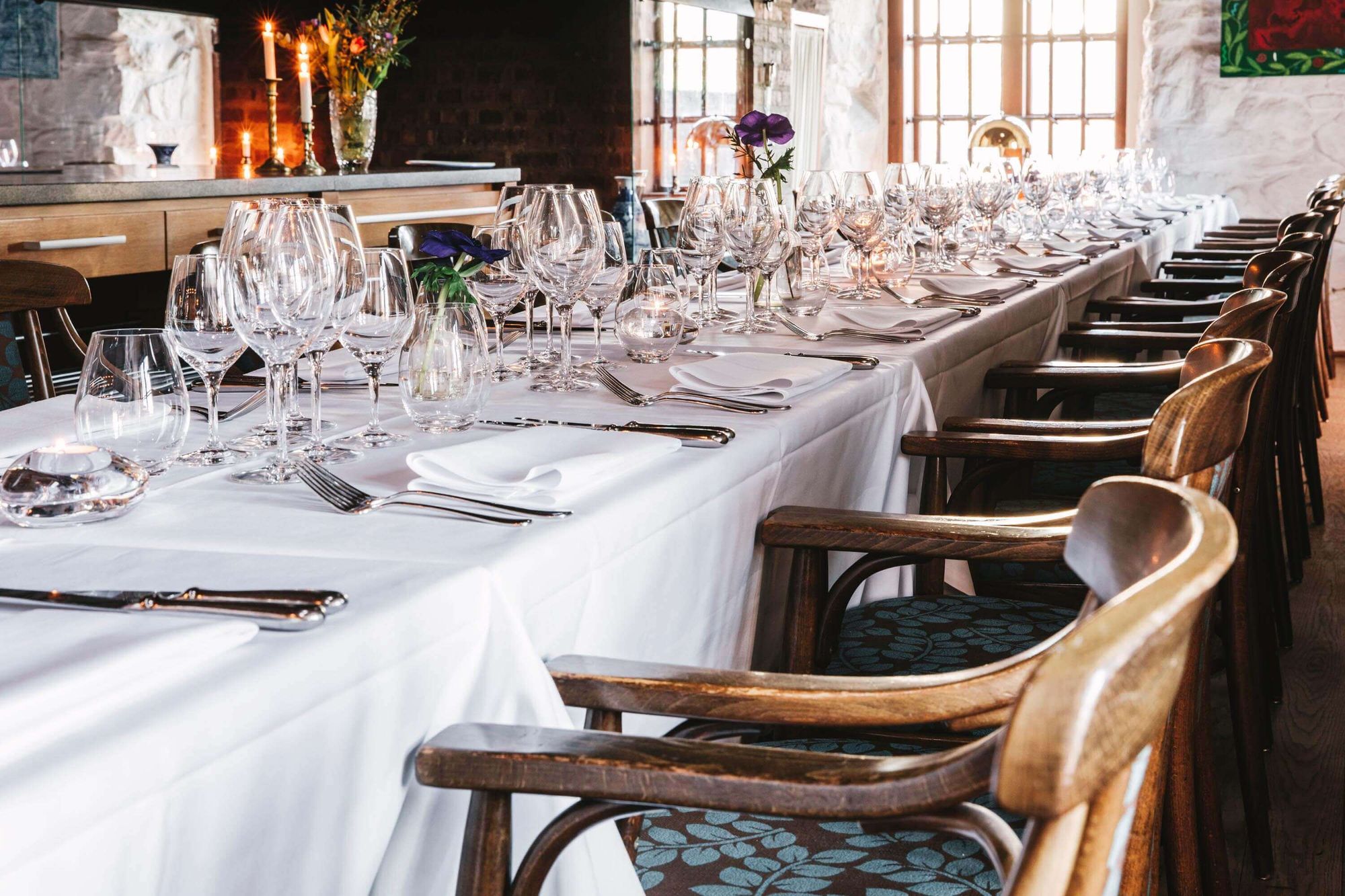 Fint uppdukat långbord med blommor och tända ljus