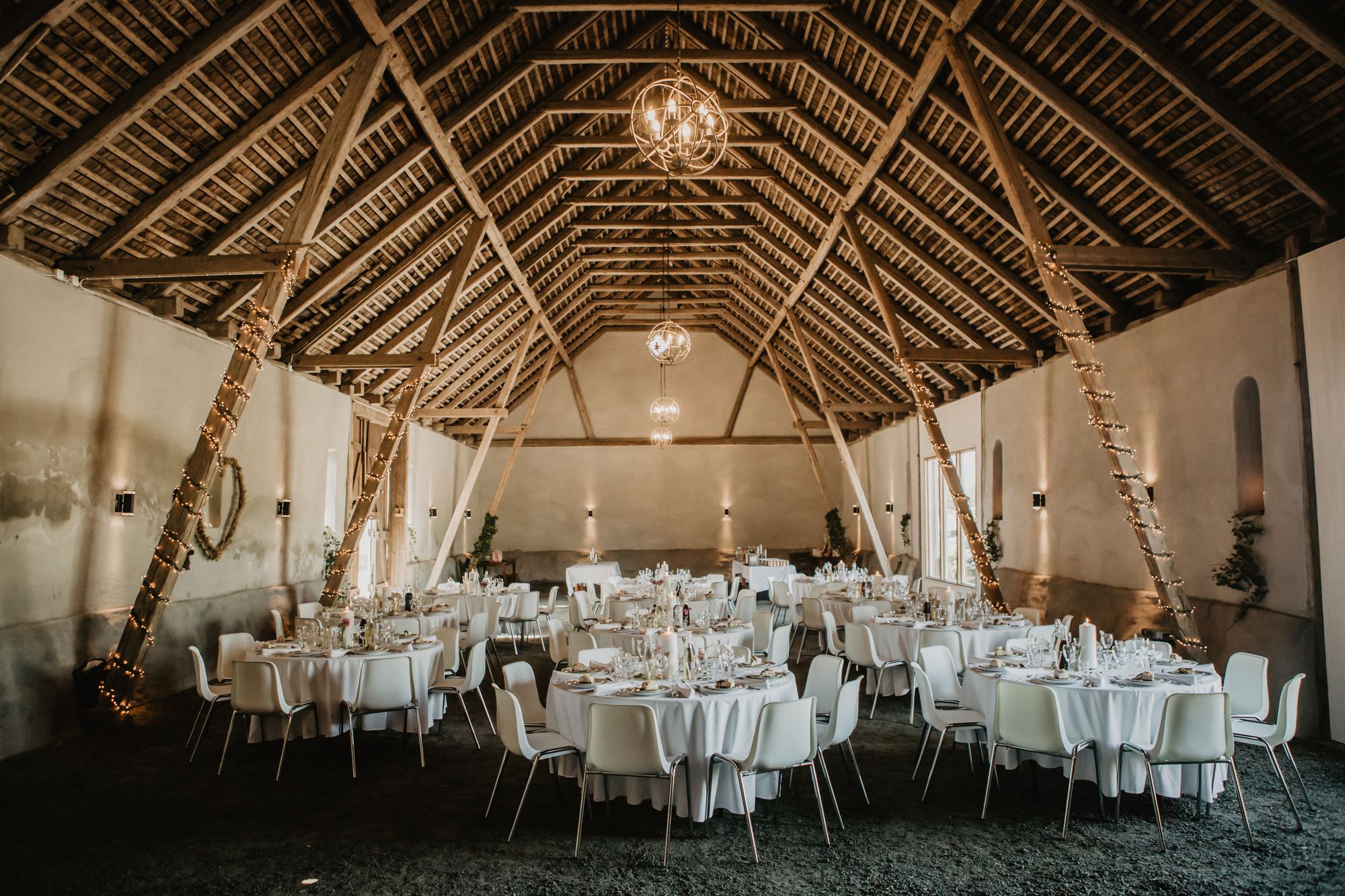 Bröllopsdekorerad lada med bord och ljusslingor
