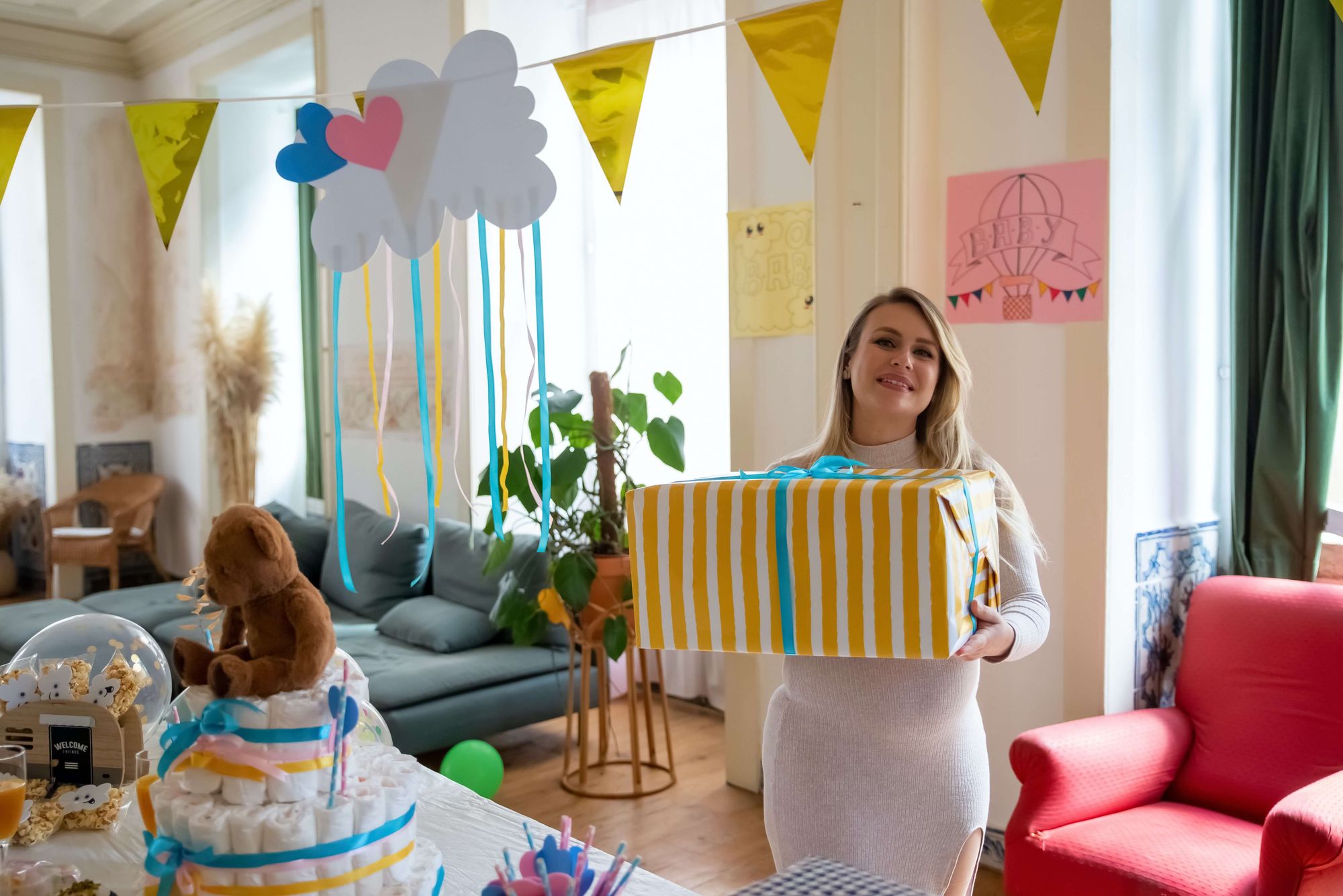 Blivande mamma på babyshower med fina dekorationer och presenter