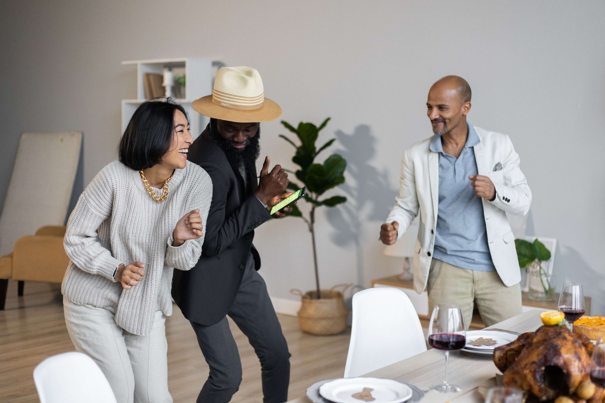 Vänner som dansar vid bordet under en middag