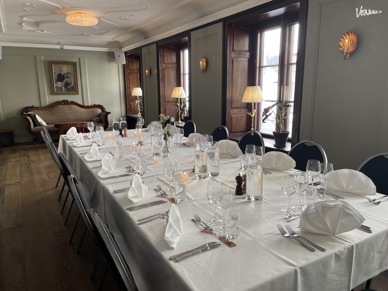 Ett klassiskt och tidlöst konferensrum med historisk inredning och träpaneler.