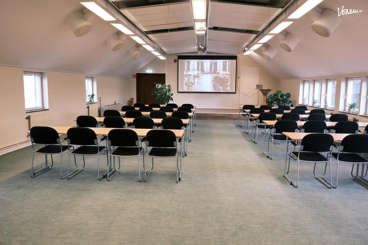 En ljus och elegant konferenslokal med botaniska inslag, stora fönster och en harmonisk atmosfär.