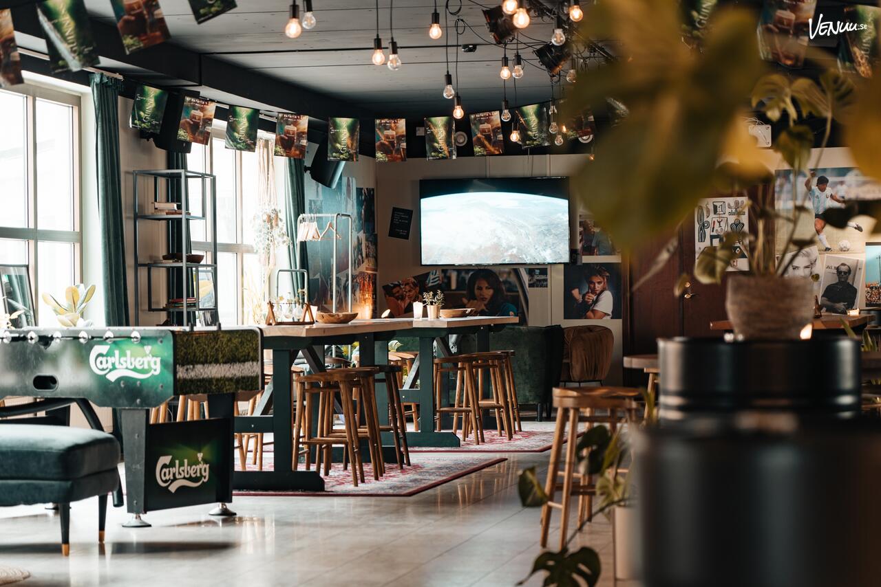 En inbjudande restauranglokal med gröna växter och en avslappnad atmosfär.