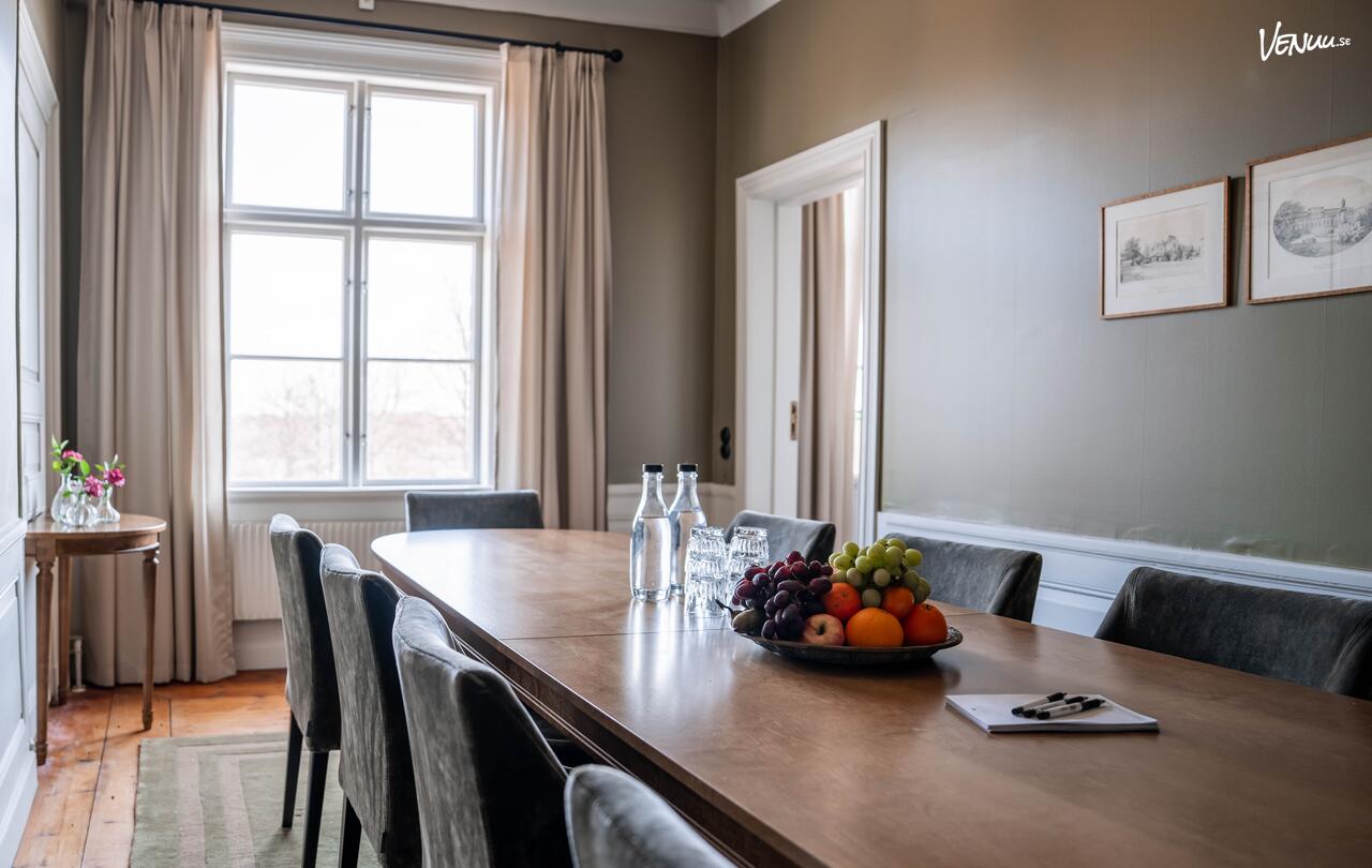 En elegant och traditionell konferenslokal i en herrgårdsmiljö, med klassiska möbler och stora fönster.