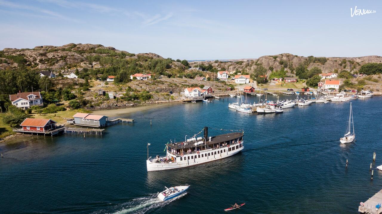 En charmig, äldre båt med rymliga däck och en klassisk skärgårdslook, full med festande gäster.