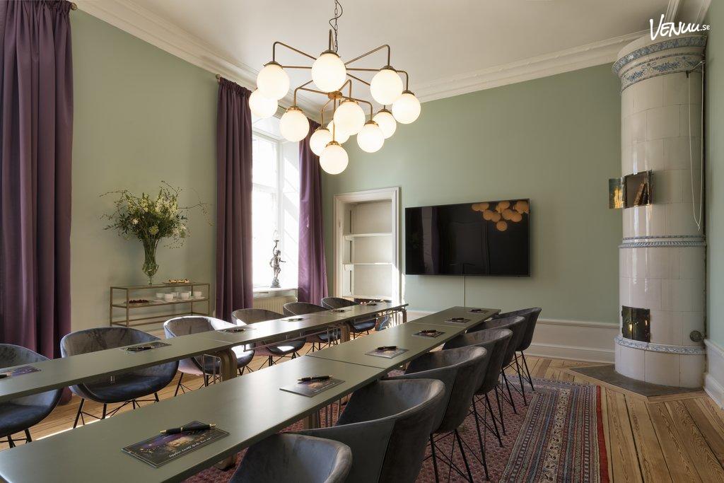 Ett avskilt och charmigt konferensrum i en villa, omgiven av natur och med sportrelaterade inslag.